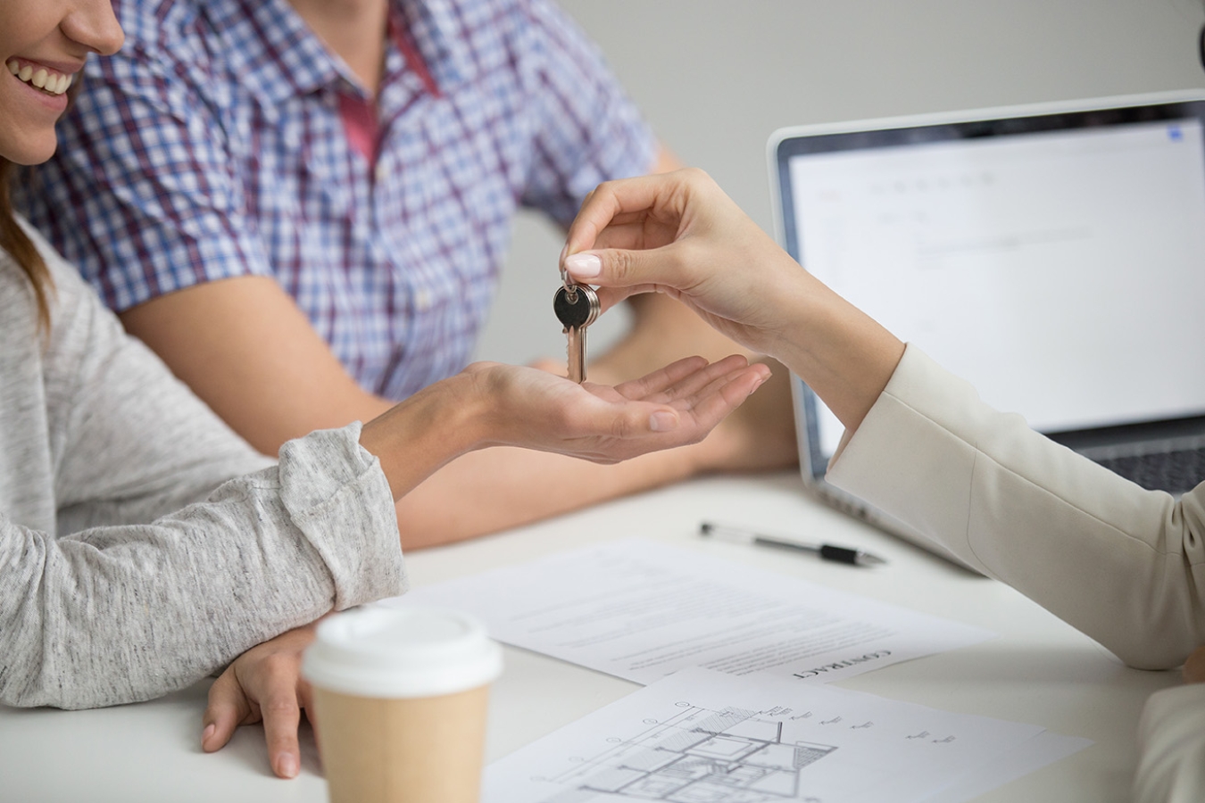 buying-new-house-concept-realtor-giving-keys-couple-closeup